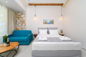 a bedroom with a bed and a blue couch at Brothers Studios & Suites in Skala Potamias
