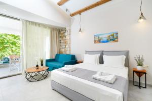 a bedroom with a large bed and a blue chair at Brothers Studios & Suites in Skala Potamias