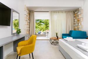 a bedroom with a bed and a living room at Brothers Studios & Suites in Skala Potamias