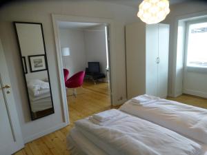 um quarto com uma cama branca e um espelho em Christianshavn Apartments 536 em Copenhaga