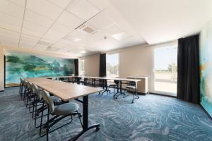a conference room with tables and chairs and a painting at Ibis Styles Miramas in Miramas
