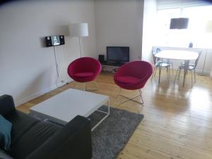 uma sala de estar com cadeiras vermelhas e uma mesa em Christianshavn Apartments 536 em Copenhaga