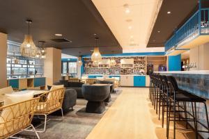 a lobby of a restaurant with chairs and a bar at Ibis Styles Miramas in Miramas