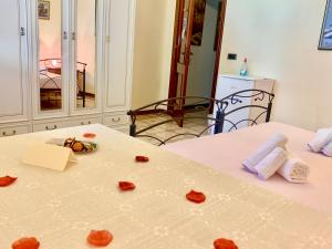 a room with two beds with red roses on a table at Bed & Breakfast Acquamarina in Castro di Lecce