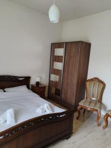 1 dormitorio con 1 cama y 1 silla en Garni Guesthouse, en Garni