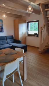 uma sala de estar com um sofá azul e uma mesa em Pokoje I Domki WIKTORIA em Będzino