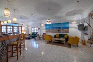 uma sala de estar com cadeiras amarelas e um bar em Argo Hotel em Amoopi