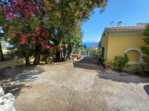 a driveway leading to a house with a tree at Olea Home in Agia Pelagia Chlomou