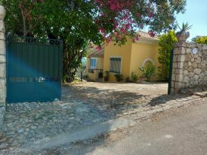 a house with a green gate in front of a driveway at Olea Home in Agia Pelagia Chlomou