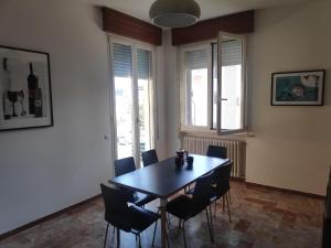 a dining room with a black table and chairs at Appartamento Panoramica in Pesaro +4 photos