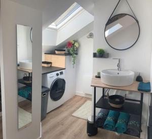 łazienka z umywalką i pralką w obiekcie Gîte La Terrasse du 37 w mieście Breteil