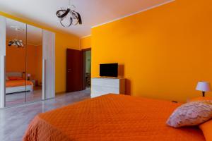 um quarto amarelo com uma cama e uma televisão em Casa Bellaria by BarbarHouse em Copertino