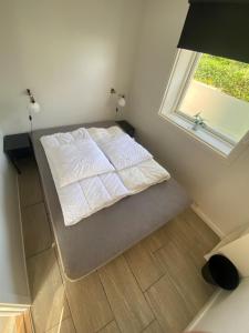 1 cama en un dormitorio con ventana en Oasen Samsø, en Nordby