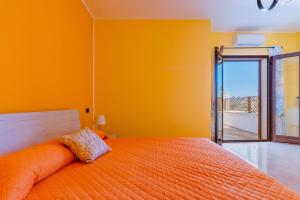 um quarto laranja com uma cama laranja e uma janela aberta em Casa Bellaria by BarbarHouse em Copertino
