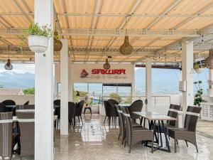 a restaurant with tables and chairs and a sign at Sakura Guest House by The Lavana in Batu