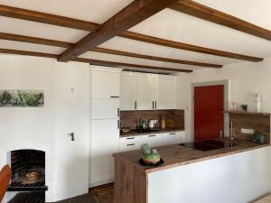 a kitchen with white cabinets and a counter with a fireplace at Ferienhaus Sonnenwinkl - Reith bei Seefeld in Reith bei Seefeld