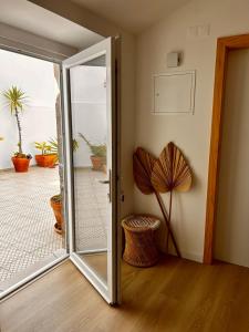 une porte coulissante en verre menant à une terrasse ornée de plantes. dans l'établissement Palmeirinha Guest House, à Sintra