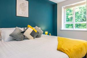 a bedroom with a bed with a yellow blanket on it at 2 bed apartment Close to the Nottingham City Centre in Nottingham