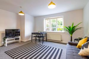 a living room with a couch and a table and a tv at 2 bed apartment Close to the Nottingham City Centre in Nottingham