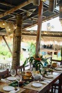 una mesa larga con platos y copas de vino. en Harana Surf Resort, en General Luna