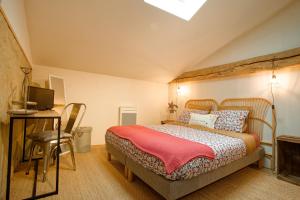 a bedroom with a bed and a desk and a television at La Belle lurette in Bressuire