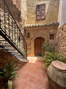 un edificio de piedra con escalera y puerta en Apartamentos turísticos "El Refugio", en Algar de Palancia