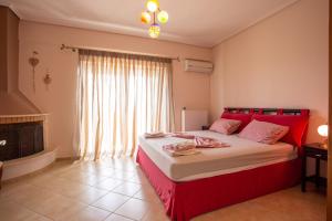 Schlafzimmer mit einem roten Bett und einem Kamin in der Unterkunft VILLA SISSY CAREFREE VACATIONSΘΕ in Theológos