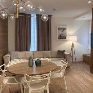 uma sala de estar com um sofá, uma mesa e cadeiras em Metropol Ceccarini Suite - Luxury apartments em Riccione