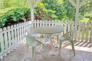 a table and chairs on a patio with a white fence at Lokoschen in Lübbenau