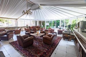 - un salon avec des canapés et des chaises dans une tente dans l'établissement Château de Floure - Hôtel, restaurant, SPA et piscine extérieure chauffée, à Floure