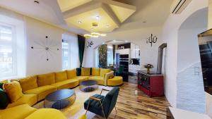 Una sala de estar con sofás amarillos y un reloj en la pared. en Apartment Bilici GmbH, en Viena