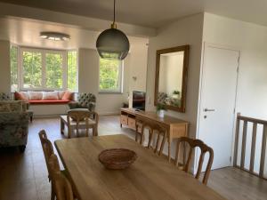 a living room with a table and chairs and a couch at Casa diatomea in De Haan
