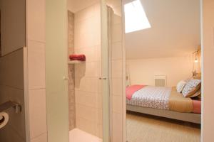 a small bedroom with a bed and a glass door at La Belle lurette in Bressuire