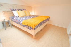 Un dormitorio con una cama con una manta amarilla. en La Belle lurette, en Bressuire
