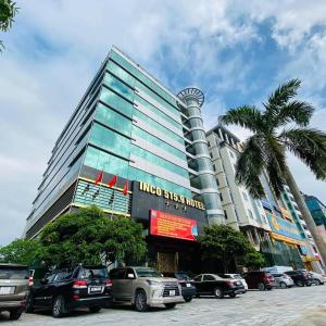 een hoog gebouw met auto's geparkeerd voor het bij Khách sạn INCO 515.9 in Phủ Lý