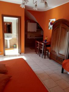 1 dormitorio con paredes de color naranja y cocina con mesa en B&b De Mauro, en Sava