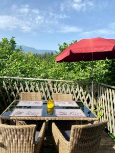 a table and chairs with an umbrella on a deck at Gold Camping Seeboden in Seeboden