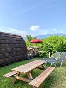 a picnic table and two chairs and an umbrella at Gold Camping Seeboden in Seeboden