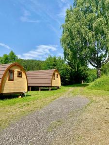 ein paar kleine Gebäude neben einem Baum in der Unterkunft Gold Camping Seeboden in Seeboden