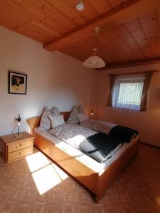 a bedroom with a wooden bed and a wooden ceiling at Haus Obweg - Postalm in Hallein