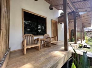 una veranda con due sedie, un tavolo e una finestra di AA Jungle Guesthouse a San Juan