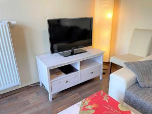 ein weißes Entertainment-Center mit einem Flachbild-TV darauf in der Unterkunft Ferienwohnungen Hopfen in Lübbenau