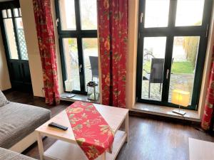 ein Wohnzimmer mit einer Couch und einem Tisch und Fenstern in der Unterkunft Ferienwohnungen Hopfen in Lübbenau