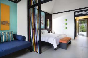 a bedroom with a bed and a blue couch at Dhawa Ihuru in Male City