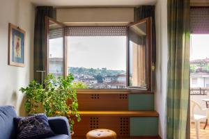 sala de estar con ventana y sofá azul en Centralissimo con vista colline, en Conegliano