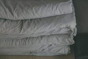 una pila de almohadas blancas apiladas una encima de la otra en Nari Nuttari Nari, en Niigata