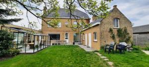 a brick house with two chairs in the yard at B&B L’Orangerie in Lo-Reninge