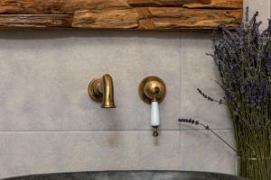 a bathroom wall with a sink and gold fixtures at Naxian Icon Luxury Residence in Naxos Chora