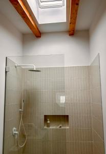 a bathroom with a shower with a glass door at Palmeirinha Guest House in Sintra