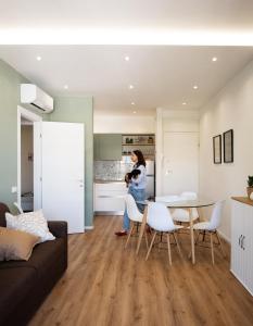 Eine Frau steht in einer Küche mit einem Tisch und Stühlen in der Unterkunft Appartamento Nautilus in Lido di Jesolo